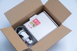 ワンタイムプランの監視カメラと電源ケーブルが段ボール箱に梱包された出荷時の状態