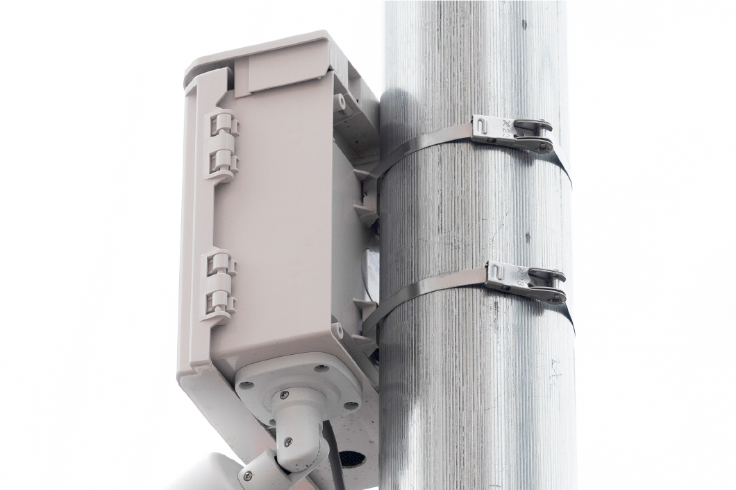 監視カメラをバンドで固定している